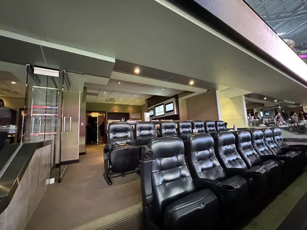 Leather, stadium-style seats within an Owners Club suite.